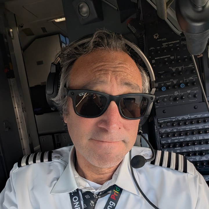 Christopher Stork in an aircraft cockpit wearing his captain's uniform